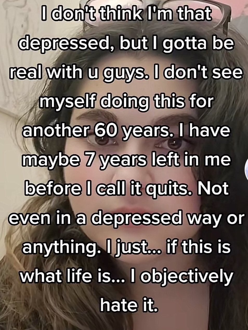 The image is a close-up selfie of a young woman with wavy brown hair, wearing glasses perched on top of her head, looking directly at the camera with a weary, deadpan, tired expression. White text with a black outline is overlaid across the full image, sharing a personal sentiment: the poster says they don't think they are severely depressed, but they cannot imagine continuing to live their current life for another 60 years, only have around 7 years of tolerance left before they call it quits, clarifying this is not a depressive or suicidal sentiment, just that they objectively hate what ordinary modern life entails.