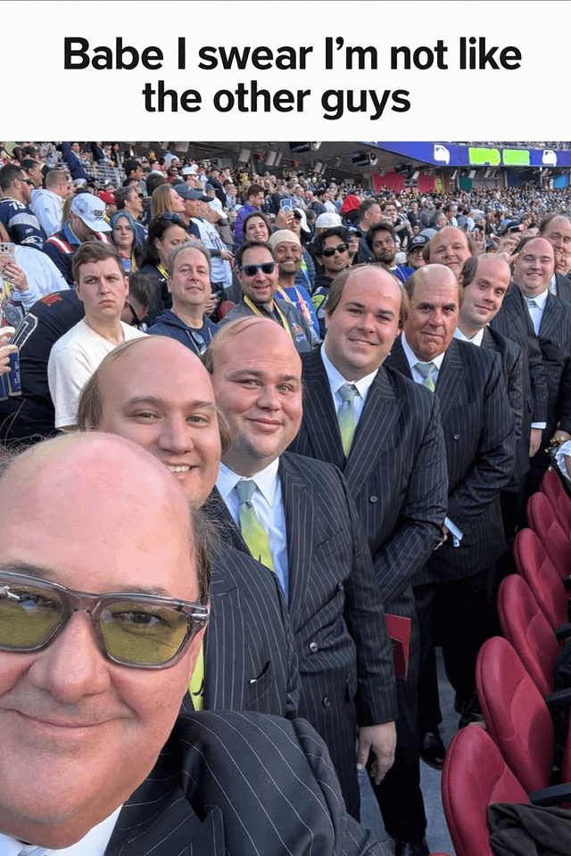 A meme image featuring a large group of men in identical pinstriped suits standing closely together in a crowded stadium. The top of the image displays the caption 'Babe I swear I’m not like the other guys,' creating a sarcastic visual joke. The men all have similar appearances—balding or short hair, neutral to smiling expressions—and are dressed uniformly, emphasizing the irony of claiming to be 'different' while looking indistinguishable from one another. The background shows a typical stadium audience, suggesting a public or sports event setting.