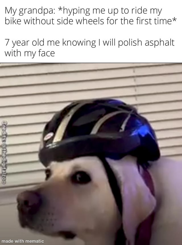 The meme features a close-up photograph of a light-colored dog (likely a Labrador Retriever) wearing a black and gold helmet. The dog has a slightly concerned expression, with its ears partially visible under the helmet. The background consists of white horizontal blinds. Above the dog, there is two-line text: the first line reads 'My grandpa: *hyping me up to ride my bike without side wheels for the first time*' and the second line reads '7 year old me knowing I will polish asphalt with my face'. At the bottom left corner, there is a small watermark that says 'made with mematic'. The humor stems from the relatable childhood anxiety of learning to ride a bike without training wheels, where the child (personified by the dog in a helmet) anticipates crashing, with 'polish asphalt with my face' being a playful, vivid description of falling face-first onto the pavement.