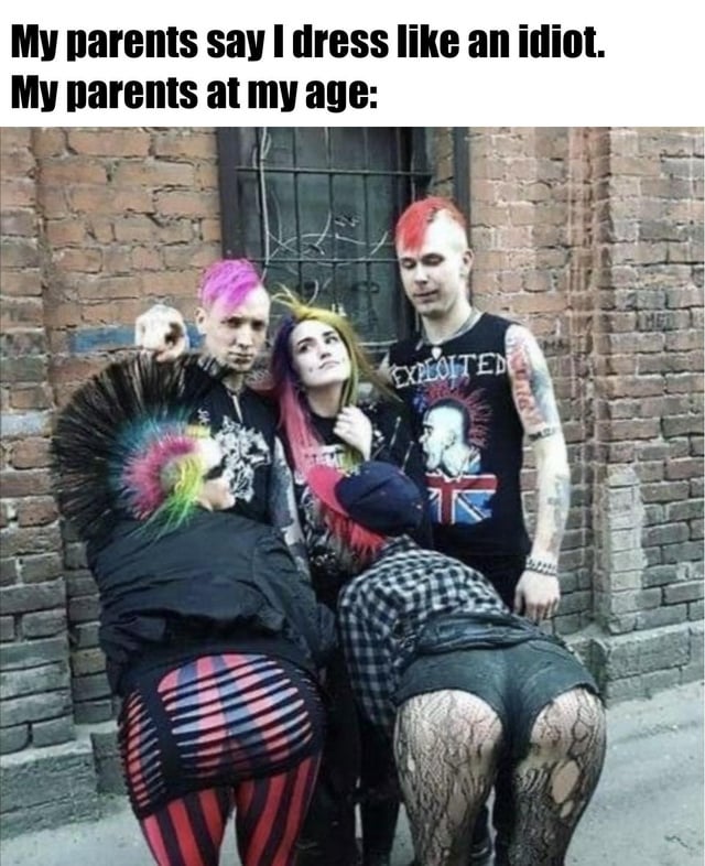 This is a relatable generational humor meme. The top text reads 'My parents say I dress like an idiot. My parents at my age:' followed by a vintage photograph of a group of 1980s/1990s punk subculture members. The group has brightly dyed mohawk hairstyles, tattoos, and edgy alternative punk clothing, with two people at the front bent over to display their ripped tights and bold, non-mainstream lower-body outfits. The joke lies in the ironic contrast, pointing out the hypocrisy of parents criticizing their children's non-conforming fashion choices when they wore similarly extreme countercultural styles at the same age.