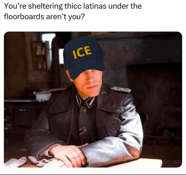 A meme featuring a person in a military-style leather jacket with epaulets, sitting at a table in a rustic room with a fireplace in the background. The individual wears a blue cap with 'ICE' written in yellow letters. Above the image, there is a caption: 'You’re sheltering thicc latinas under the floorboards aren’t you?' The character has a serious, questioning expression, creating a satirical or humorous tone.