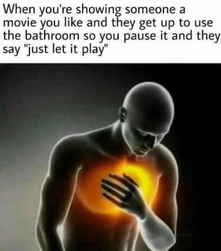The meme features a vertical layout with a top text panel and a lower image. The text reads: 'When you're showing someone a movie you like and they get up to use the bathroom so you pause it and they say "just let it play"'. Below the text is an image of a bald, shirtless animated human figure with a glowing orange light emanating from their chest. The figure has one hand placed over the glowing chest and their head bowed downward, conveying a sense of emotional distress or heartache, likely representing the frustration of the movie enthusiast.