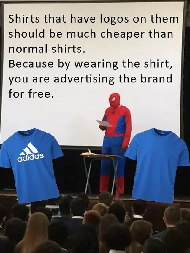 This meme uses the popular 'Spiderman Giving a Presentation' template. It features a person in a full Spider-Man costume standing on a stage in front of a seated audience, presenting a slide with a relatable consumer-focused argument: 'Shirts that have logos on them should be much cheaper than normal shirts. Because by wearing the shirt, you are advertising the brand for free.' Two blue shirts are overlaid at the bottom of the image for comparison: one with the Adidas brand logo, and a plain unbranded blue shirt. The humor comes from framing a logical, everyday complaint about branded apparel pricing as a formal, serious presentation, paired with the absurd visual of Spider-Man delivering the talk, creating a funny contrast between the silly character and the mundane, relatable argument.
