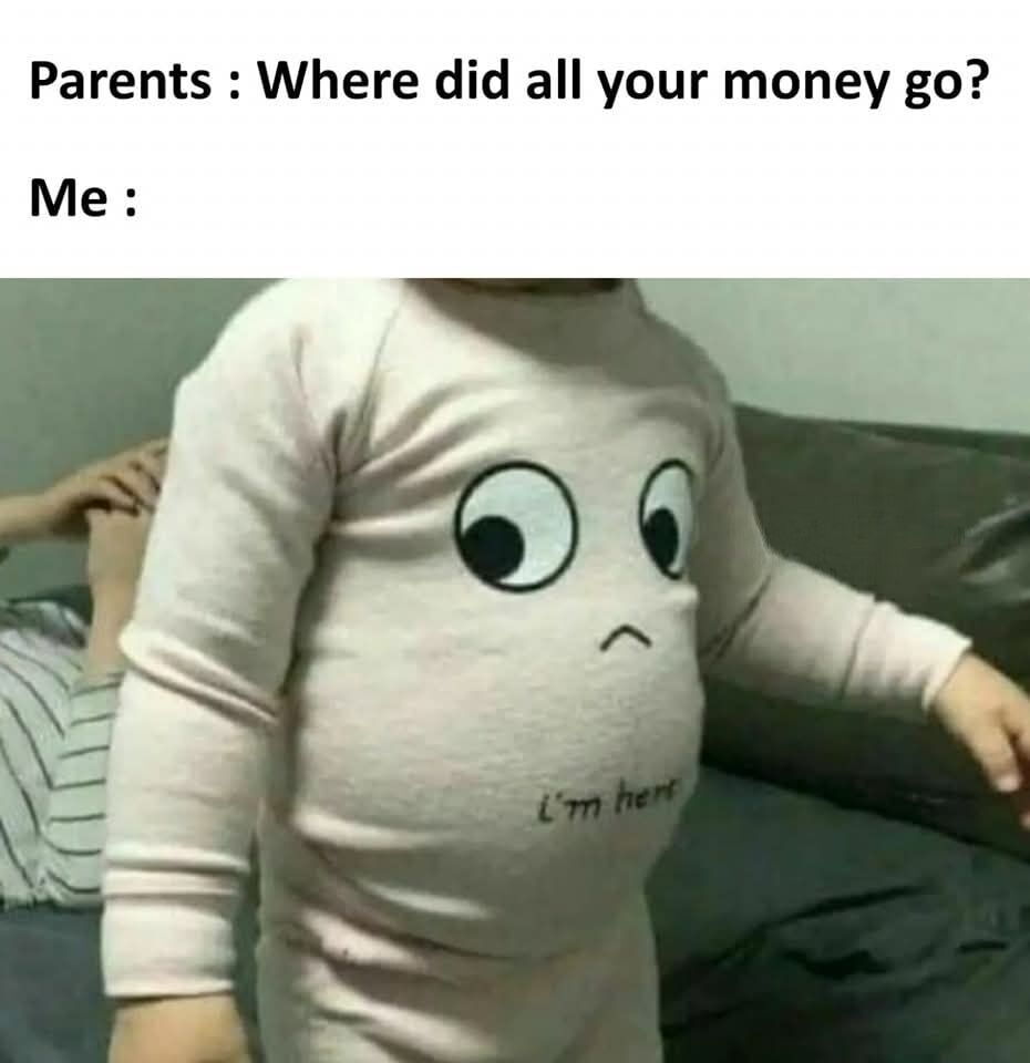 This relatable meme is structured with text at the top setting up a common everyday scenario: the first line reads 'Parents : Where did all your money go?', followed by 'Me :' leading into the image below. The image shows a young child standing in front of a dark grey couch, wearing a pale pink long-sleeve onesie. The onesie has a cartoon sad face printed on the child's prominent round belly, with partial text below the face reading 'I'm here'. The joke is a humorous visual pun: it implies all the money the person spent was on food, so the money effectively became the fat stored in their belly, which is represented by the face on the child's stomach indicating it is where the money went.