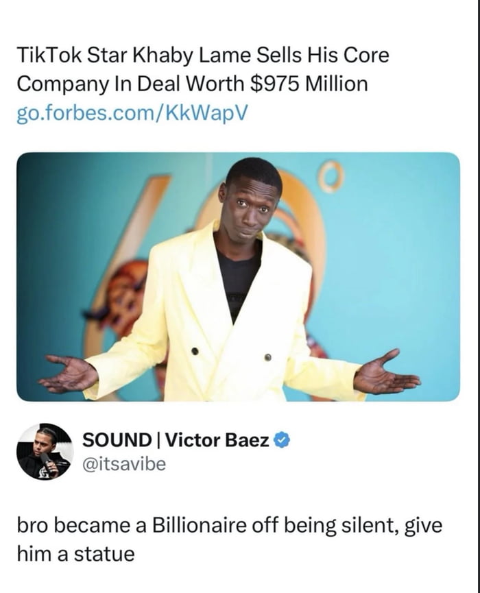 A meme featuring a news headline claiming TikTok star Khaby Lame sold his core company for $975 million, accompanied by a photo of Lame in a yellow suit with arms outstretched. Below the headline is a comment from Twitter user Victor Baez (@itsavibe) joking that Lame became a billionaire by being silent, suggesting he deserves a statue. The humor lies in the contrast between Lame's silent, expressive content and his massive financial success.