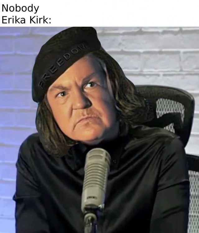 This meme uses the widely popular 'Nobody' or 'No one:' template, which is designed to mock people who interject with unsolicited, unprompted opinions when no one has requested their input. The top text reads 'Nobody' followed by 'Erika Kirk:', below which is a photo of public figure Erika Kirk sitting in front of a podcast microphone. She wears a black beanie embroidered with the word 'FREEDOM', has a scowling, grumpy expression, and is looking off-camera as if she is about to speak unprompted. The joke plays on two elements: Erika Kirk's public reputation for outspoken conservative commentary, and her visual resemblance to characters from the 1987 comedy film *Throw Momma From The Train*, which is referenced in the original post title.