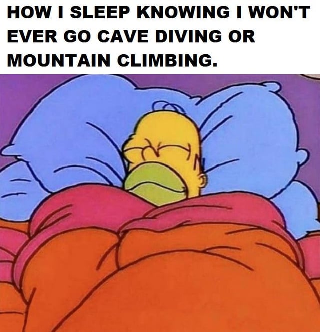 This single-panel meme uses a classic screencap of Homer Simpson from the animated series *The Simpsons* sleeping peacefully in bed, tucked under blankets with multiple pillows supporting his head. The text at the top reads "HOW I SLEEP KNOWING I WON'T EVER GO CAVE DIVING OR MOUNTAIN CLIMBING." The joke refers to widespread internet discourse about the extremely high, often fatal risks associated with cave diving and mountain climbing, poking fun at the immense relief people feel when choosing to avoid these dangerous activities entirely, referencing the common "Do Not The Mountain" internet phrase that warns against mountain climbing hazards.