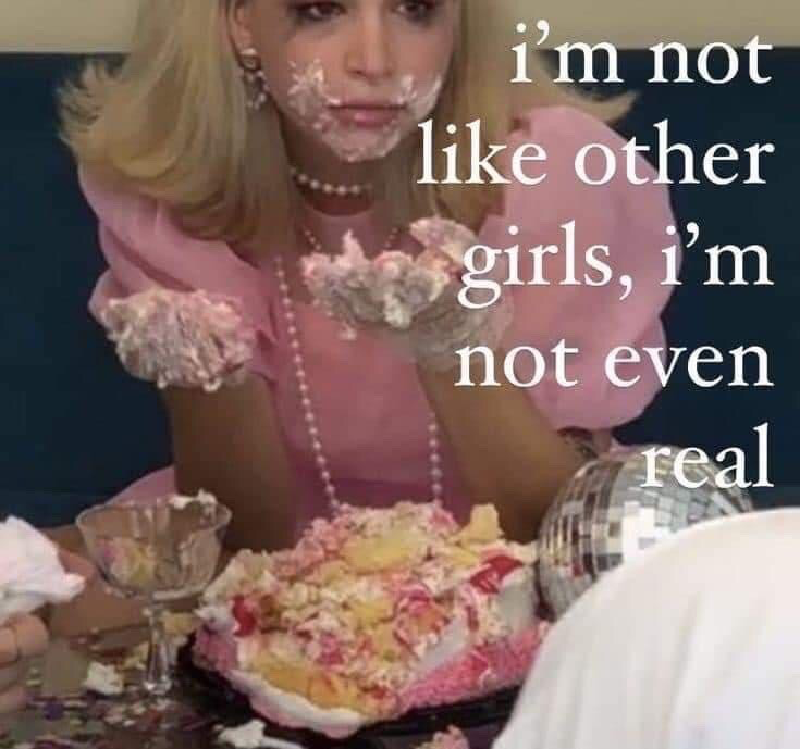 The image features a blonde woman wearing a pink dress and pearl jewelry, with her face and hands completely covered in white cake frosting. She sits in front of a heavily destroyed, half-eaten pink and white cake, a partially emptied dessert glass, and a small disco ball on the table. White overlaid text on the right side of the image reads, "i'm not like other girls, i'm not even real". The joke subverts the common, often mocked "I'm not like other girls" internet trope, adding an absurd, surreal punchline that matches the uncanny, over-the-top messy appearance of the scene.
