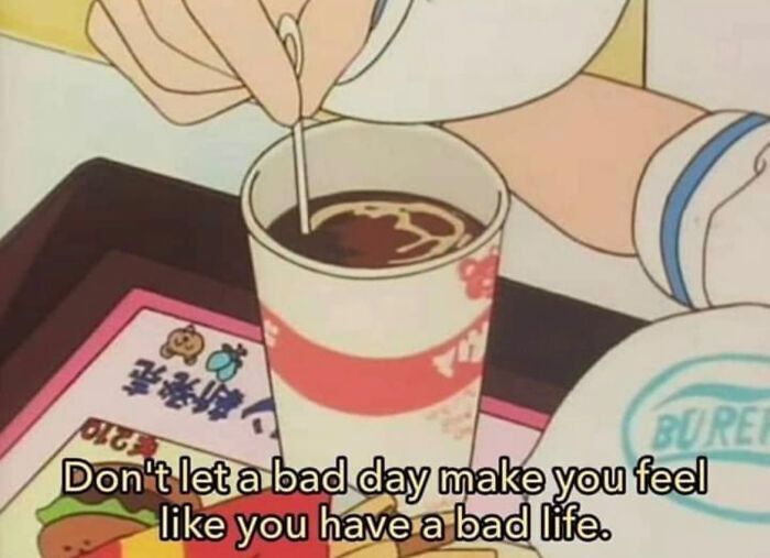 This wholesome meme features a cropped screenshot from an unknown 90s-style slice-of-life anime, showing an animated character's hand stirring a dark drink in a disposable cup placed on a fast food tray. The tray includes Japanese text and cartoon graphics of food items. Overlaid at the bottom of the image is a gentle, reassuring message: *Don't let a bad day make you feel like you have a bad life.* The scene conveys a calm, comforting atmosphere, paired with a positive reminder to separate temporary hardships from one's overall life experience.