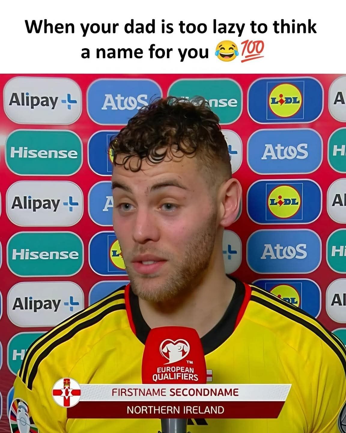 This meme features a screenshot of a Northern Irish football player giving an interview during the UEFA European Qualifiers, standing in front of a backdrop of sponsor logos including Alipay, Atos, Hisense, and Lidl, speaking into a European Qualifiers branded microphone. A lower-third broadcast graphic incorrectly displays placeholder text reading 'FIRSTNAME SECONDNAME' as the player's name, with 'NORTHERN IRELAND' listed below it. A caption added at the top of the image reads 'When your dad is too lazy to think a name for you 😂💯', joking that the generic placeholder name is the actual given name of the player, chosen by an unmotivated father. The joke relies on the fact that 'Firstname Lastname' is a universally recognized placeholder for personal names, making the error appear to be a hilariously uncreative given name.