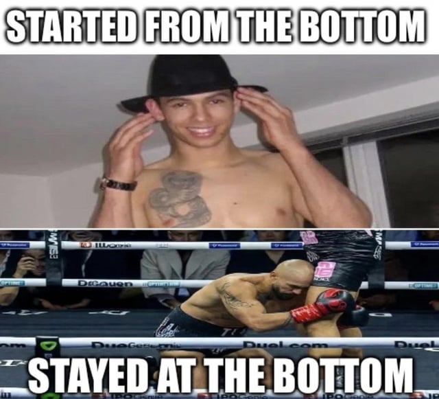 A two-panel meme contrasting aspirational rhetoric with humorous failure. The top panel shows a shirtless man with a chest tattoo adjusting a black hat, smiling confidently, with bold text 'STARTED FROM THE BOTTOM' above him. The bottom panel depicts a bald MMA fighter in a ring, wearing black shorts and red gloves, kneeling as he appears to be kicked in the face, with the text 'STAYED AT THE BOTTOM' below. The joke subverts the励志 message of Drake's song by showing a character who never progresses beyond their starting point.