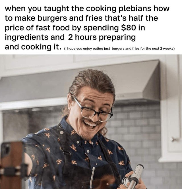 A meme featuring a man in a modern kitchen, wearing a dark shirt with small patterns and a black apron, smiling widely while holding a phone (likely recording a tutorial). Above the image is a text overlay mocking a 'budget' cooking tutorial scenario: teaching others to make burgers and fries 'half the price of fast food' by spending $80 on ingredients and 2 hours preparing, resulting in being forced to eat the same meal for 2 weeks. The humor stems from the irony of an inefficient 'money-saving' hack.