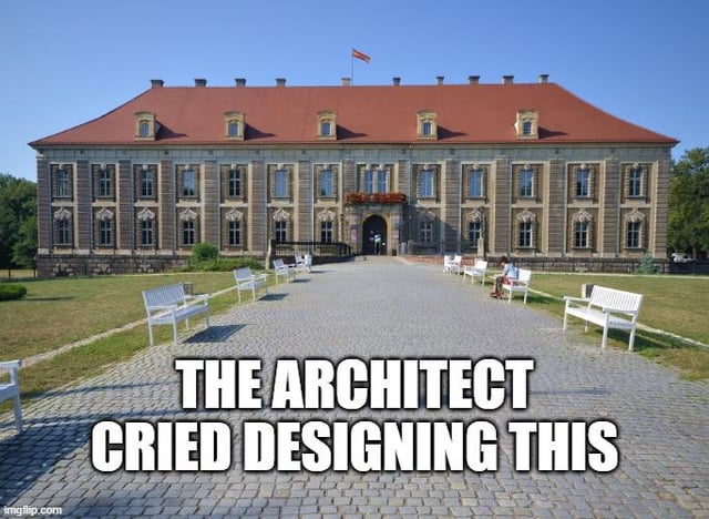This meme shows a photograph of a large, symmetrical historic building with an otherwise perfectly aligned facade, roof, and surrounding landscaping. The only noticeable flaw is that one of the five dormer windows on the red roof is slightly wider than the other four, breaking the perfect symmetry that the rest of the building follows. The overlaid text reads "THE ARCHITECT CRIED DESIGNING THIS", creating a joke that this tiny imperfection would bother any perfectionist, both the original architect and anyone viewing the building who is obsessive about order and symmetry.