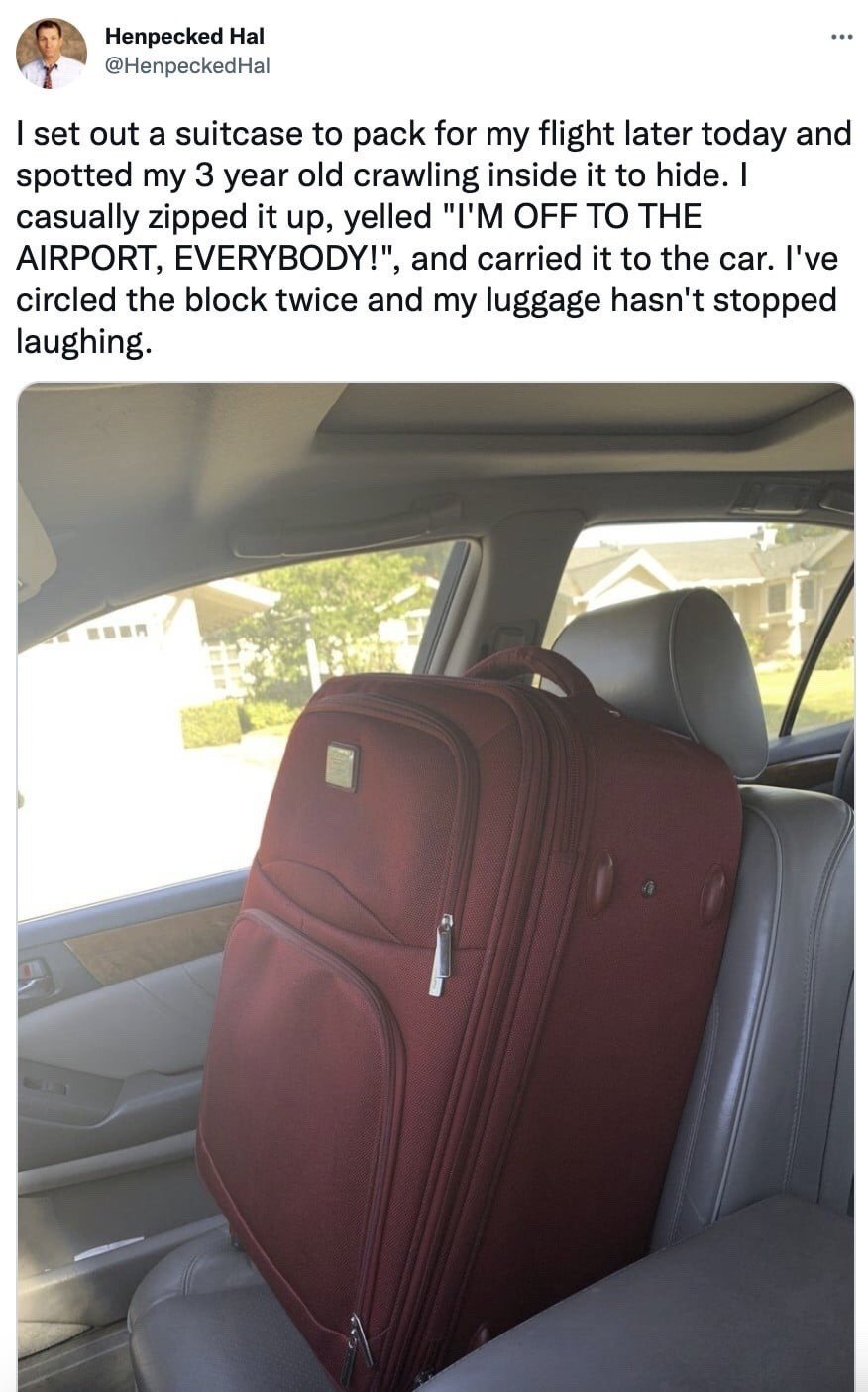 This image is a screenshot of a viral X (formerly Twitter) post. The text of the post, written by user Henpecked Hal, recounts a playful prank: the poster was preparing to pack a suitcase for an upcoming flight when he found his 3-year-old child hiding inside the suitcase. He pretended not to notice the child, zipped the suitcase closed, announced he was leaving for the airport, carried the suitcase to his car, and drove around his neighborhood block twice, with the child laughing continuously from inside the closed suitcase the entire time. The attached photo below the text shows the closed maroon rolling suitcase standing upright on the back passenger seat of the poster's car, with suburban houses and greenery visible through the car windows.