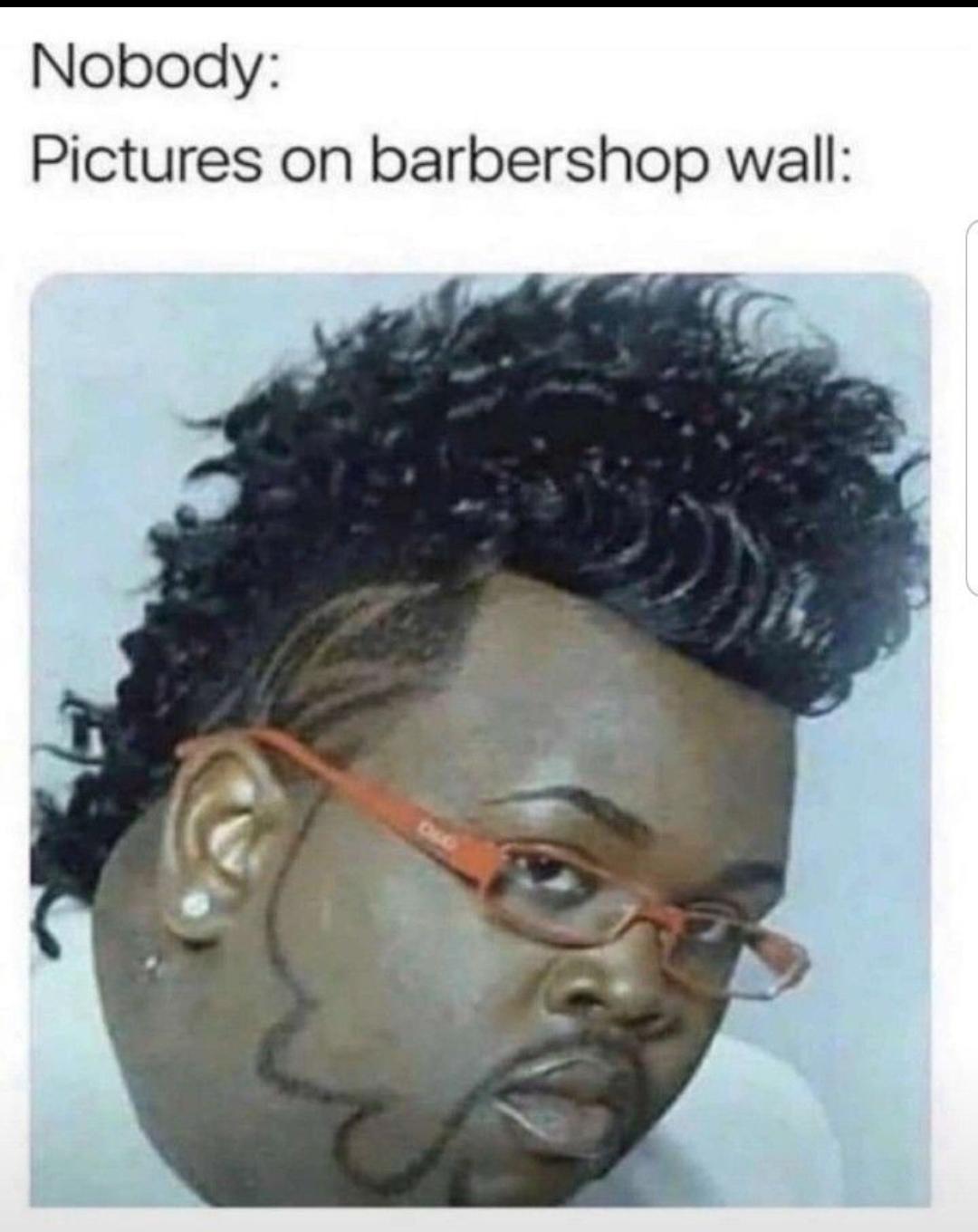 A meme utilizing the popular 'Nobody:' format. The top text reads 'Nobody:' followed by 'Pictures on barbershop wall:', with a photograph below depicting a person with an extremely elaborate, voluminous curly hairstyle. The individual is wearing red-framed glasses and a small earring, posing with a neutral expression. The humor stems from the夸张 and unrealistic nature of the hairstyle, satirizing the often over-the-top examples displayed on barbershop walls to showcase their styling capabilities.