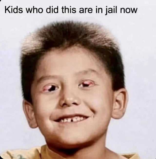 A meme image featuring a young child with short dark hair, a mischievous smile, and prominently red-colored eyes (likely edited for effect). At the top of the image, bold black text reads: 'Kids who did this are in jail now'. The humor arises from the absurd contrast between the child's innocent, playful appearance and the severe implication that their actions resulted in incarceration, creating a sarcastic and darkly funny tone.