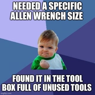 A meme featuring a real baby with a grumpy or determined expression, fists clenched, and looking forward, set against a colorful geometric background. The top text reads 'NEEDED A SPECIFIC ALLEN WRENCH SIZE' and the bottom text states 'FOUND IT IN THE TOOL BOX FULL OF UNUSED TOOLS'. The humor stems from the relatable everyday situation of searching through a cluttered toolbox and finally finding the needed specific tool, personified by the baby's determined demeanor.
