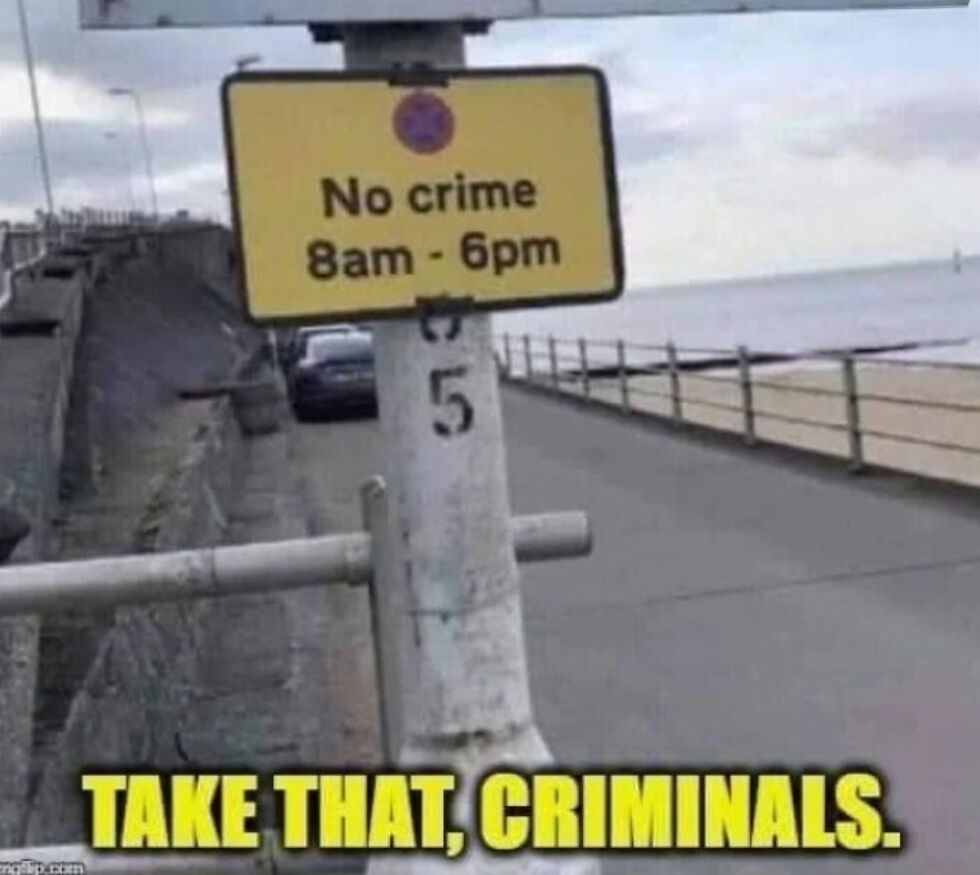 This meme features a photograph of a yellow street sign mounted on a numbered metal pole along a coastal pedestrian walkway, with a paved road, parked car, and ocean visible in the background under an overcast sky. The sign is edited to read 'No crime 8am - 6pm', and large bold yellow impact font text at the bottom of the image reads 'TAKE THAT, CRIMINALS.'. The core joke relies on the absurdity of the rule: the sign implies that crime is only prohibited during standard daytime working hours, and is allowed at all other times, and sarcastically frames this useless, unenforceable restriction as if it will successfully stop criminals from acting, mocking ineffective, poorly thought out laws and regulations that do nothing to address the problem they claim to solve.