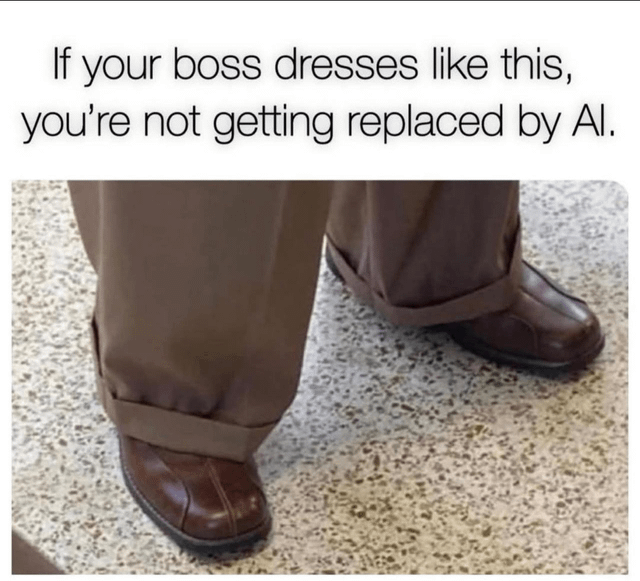 A meme consisting of a top text caption and a photograph. The text reads: 'If your boss dresses like this, you're not getting replaced by AI.' Below the text is a photograph showing the lower legs and feet of a person standing on a speckled floor. The individual is wearing brown pants with unevenly rolled cuffs that awkwardly cover the tops of brown leather shoes, suggesting unprofessional or quirky fashion. The humor hinges on the implication that a boss with such distinctive (and presumably inefficient or idiosyncratic) fashion sense has a management style too unique or unpredictable for AI to replicate, thus ensuring job security for their employees.
