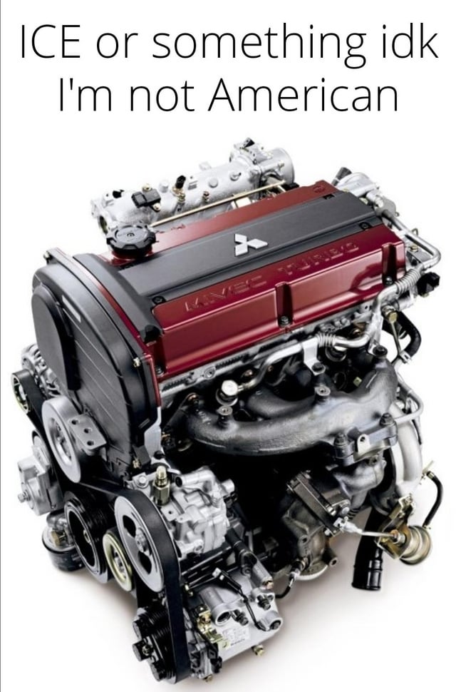 The image features a high-quality photograph of a Mitsubishi KVSC Turbo engine, showcased against a plain white background. The engine has a distinctive red and black cover with the Mitsubishi logo prominently displayed. At the top of the image, white text reads: 'ICE or something idk I'm not American'. The engine's mechanical components, including belts, pulleys, and various metallic parts, are clearly visible, emphasizing its detailed engineering. The humor in the meme arises from the creator's feigned confusion about 'ICE' (likely an abbreviation for Internal Combustion Engine) paired with the disclaimer 'I'm not American', suggesting unfamiliarity with American automotive terminology or context.