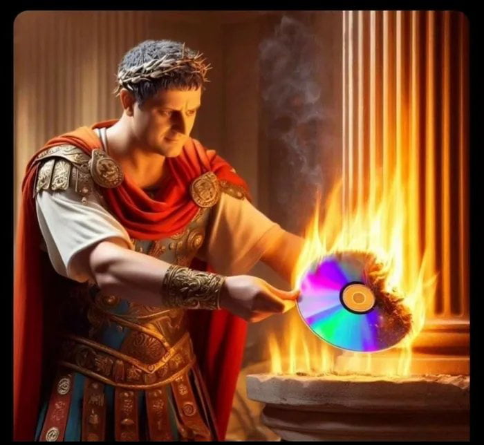 An image depicting a person dressed in ancient Roman clothing, including a laurel wreath, red toga, and ornate armor, standing in a classical Roman interior with fluted columns. The figure holds a CD-ROM (compact disc) that is actively burning, with flames visible around the disc. The scene combines historical ancient Roman elements with modern technology (the CD-ROM), creating a surreal and humorous contrast between past and present.