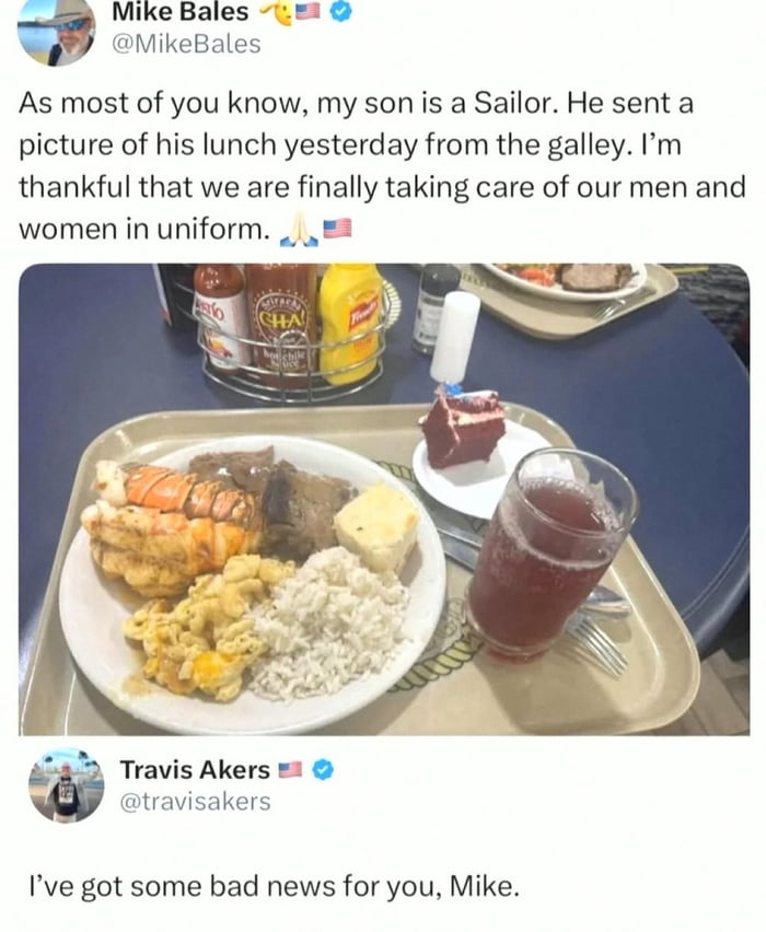 This image is a screenshot of a viral Twitter/X thread with an ironic joke. The first tweet comes from verified user Mike Bales, who shares that his son is a US Navy sailor, and his son sent this photo of a high-end luxurious lunch (including giant king crab legs, steak, cake, and other premium items) from the ship's galley. Mike states he is grateful that the US military is finally properly taking care of its uniformed service members. Below the photo, verified user Travis Akers replies with the punchline: 'I've got some bad news for you, Mike.' The implied joke is that the son did not eat this meal himself -- he most likely works as a cook or steward who prepared this fancy meal for officers, so Mike's positive conclusion about improved standard military food is wrong.