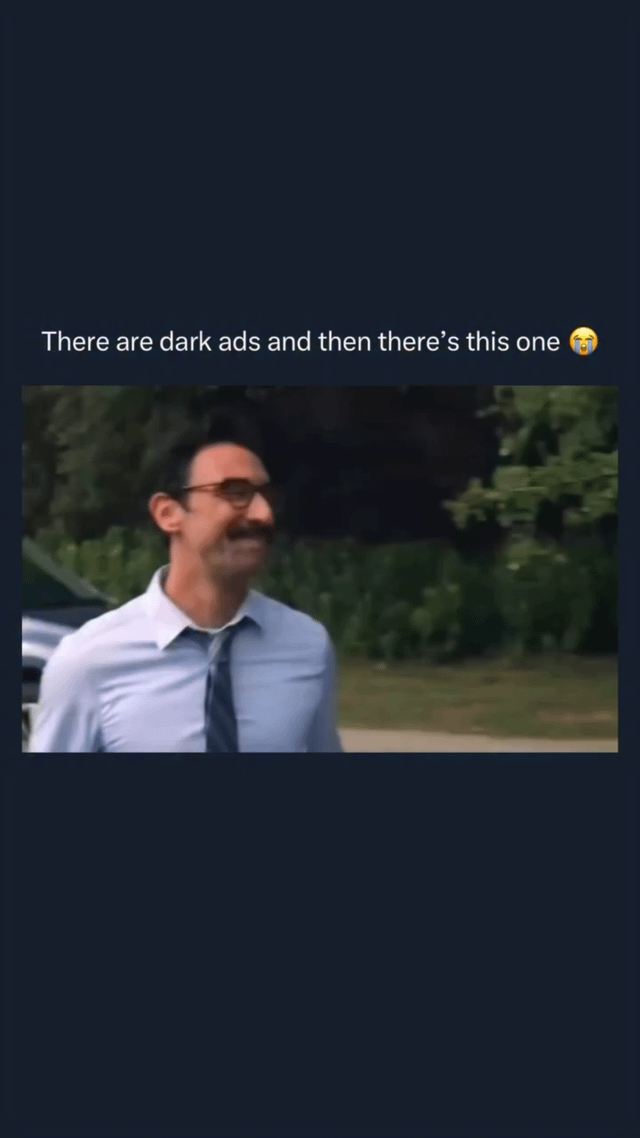 A meme consisting of a top text comment reading 'There are dark ads and then there's this one 😂' above a screenshot of a man. The man is wearing a light blue dress shirt with a loosely tied dark tie, smiling amusedly, and standing outdoors with greenery (bushes and trees) in the background. The combination of the text and the man's expression humorously highlights an absurd or overly 'dark' advertisement by contrasting it with typical dark ads.