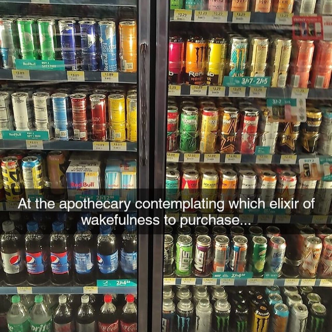 The image displays a double-door glass-fronted convenience store refrigerator fully stocked with a large assortment of caffeinated beverages, including multiple flavors of Red Bull, Monster, Rockstar energy drinks, plus common sodas like Pepsi, Sprite, and Coca-Cola across all shelves. White overlaid text across the center reads 'At the apothecary contemplating which elixir of wakefulness to purchase...'. The humor comes from the playful exaggerated framing: a regular convenience store cooler is compared to an old-fashioned apothecary shop, and caffeinated energy drinks are framed as magical or medicinal elixirs intended to cure tiredness and keep the consumer awake, a relatable joke for anyone who relies on caffeine for energy.