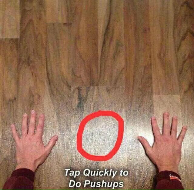 This is a playful prank meme image. It displays two real human hands positioned on a wooden floor, mimicking the starting stance of a push-up. A red circle highlights an empty area between the hands, and the text below reads **Tap Quickly to Do Pushups**. The joke is a fake interactive prompt—viewers cannot actually interact with the static image to perform pushups, making it a lighthearted trick that plays on expectations of digital interactive content.