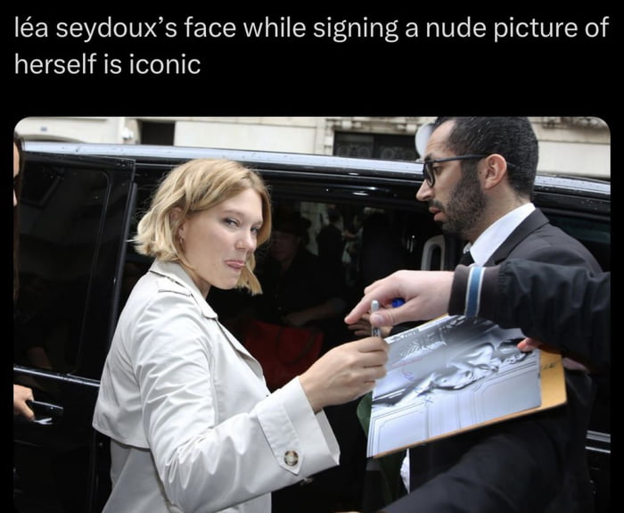 This meme features a candid paparazzi photo of actress Léa Seydoux exiting a black SUV after a public event. She is stopped by a fan asking for an autograph, and the print she is being asked to sign is a nude photograph of Léa herself. Her awkward, side-eyeing, slightly annoyed yet resigned facial expression in this moment is called iconic in the added text at the top of the image. The humor comes from the uncomfortable and awkward situation of a celebrity being asked to sign a nude picture of themselves by a fan, captured perfectly in her very relatable reaction.