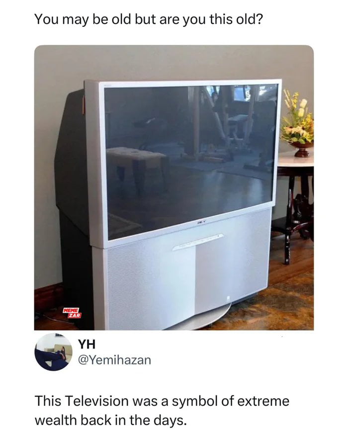 This meme uses nostalgia for outdated technology to create humor. The top text asks, "You may be old but are you this old?" above a photograph of a large, bulky rear-projection CRT television, which was a luxury status symbol when it was released. Below the image, a snippet of a Twitter/X post from user @Yemihazan states, "This Television was a symbol of extreme wealth back in the days." The joke resonates with audiences who remember when owning such a massive, high-end TV was a sign of affluence, contrasting with today's slim, affordable flat-screen TVs. It evokes feelings of nostalgia and amusement at how quickly technology and status symbols change over time.