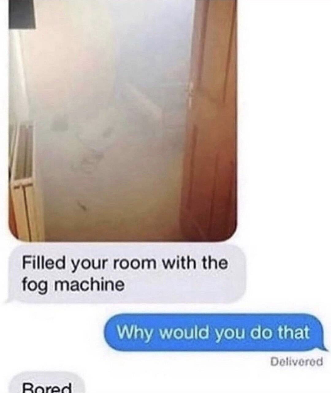 This image is a screenshot of an Apple iMessage conversation. At the top, there is a photograph of a residential room completely filled with thick white fog, making most of the room's contents and layout impossible to see. Below the photo, the first grey incoming text bubble reads 'Filled your room with the fog machine'. The blue outgoing reply bubble reads 'Why would you do that', with a 'Delivered' status label underneath it. The very top of a final incoming grey bubble is visible, showing the partial word 'Bored' as the start of the prankster's explanation for their action. The joke relies on the absurdity of doing a dramatic, inconvenient prank for no reason other than being bored.