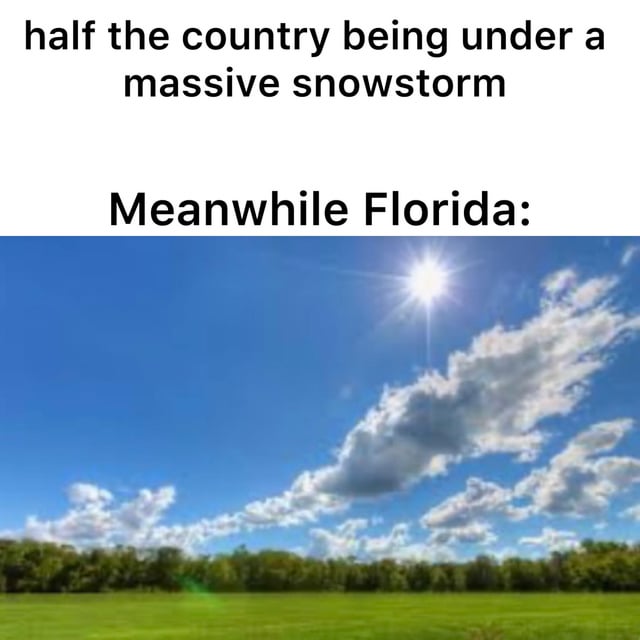 A meme consisting of two sections: the top section contains black text on a white background that reads 'half the country being under a massive snowstorm' followed by 'Meanwhile Florida:', and the bottom section is a photograph of a bright, sunny landscape with a clear blue sky, scattered clouds, a visible sun, and green fields. The meme humorously contrasts the severe winter weather affecting much of the country with Florida's typically mild, sunny climate.