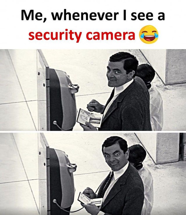 This is a two-panel relatable humor meme. The top text reads "Me, whenever I see a security camera" paired with a laughing crying emoji. Both panels use black and white footage of the character Mr. Bean from the classic British comedy series: the first panel shows Mr. Bean standing next to a public payphone, holding a small booklet, turning to look up with a small amused smile at the implied security camera. The second panel shows him making an exaggerated, wide-eyed goofy silly face directly at the camera, referencing the very common lighthearted habit many people have of making funny faces when they notice they are being recorded by public security cameras.