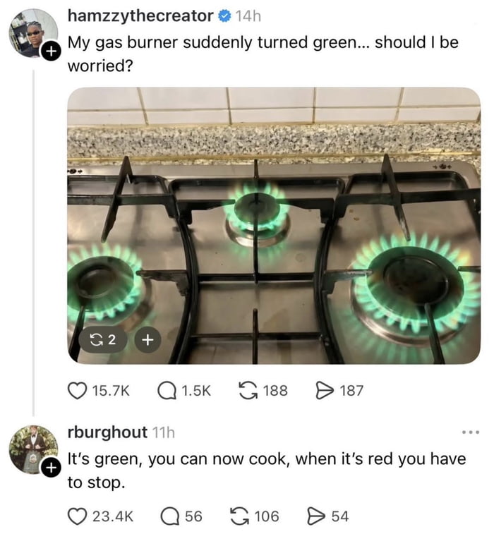 This image is a screenshot of a social media thread. First, user hamzzythecreator shares a photo of their kitchen gas stove with three burners emitting unusual bright green flames, asking if they should be worried about the odd flame color. A reply from user rburghout makes a deadpan joke comparing the green flames to traffic light signals, stating that green means you can cook, while red would mean you need to stop. The humor comes from the absurd application of traffic light rules to a potentially dangerous gas appliance issue, ignoring the actual safety risk of incorrectly burning gas that produces green flames.