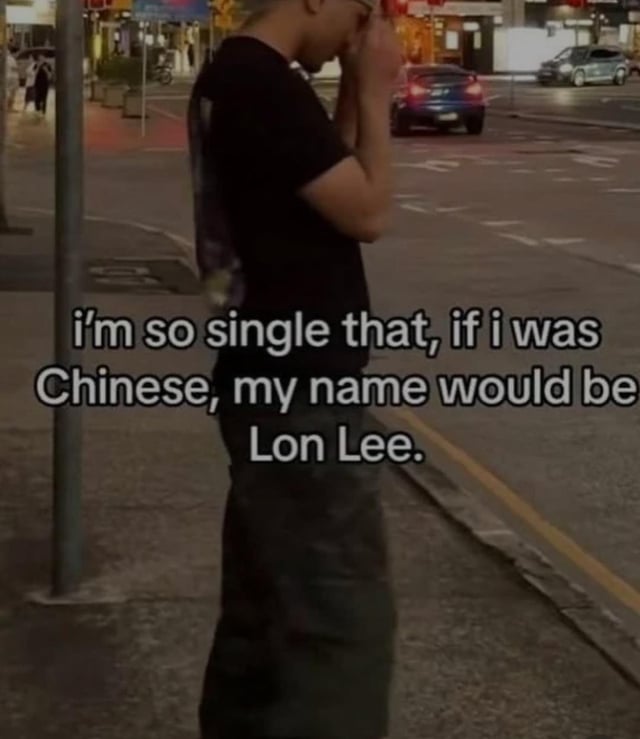 This meme combines a somber real-life photograph of a person looking lonely (head in hands, leaning against a pole on a nighttime city sidewalk) with a punny text overlay. The core joke is a phonetic pun: 'Lon Lee' sounds identical to the English word 'alone', framing extreme singleness as a hypothetical Chinese name. The visual's dejected tone matches the self-deprecating, relatable humor about feeling lonely and single.