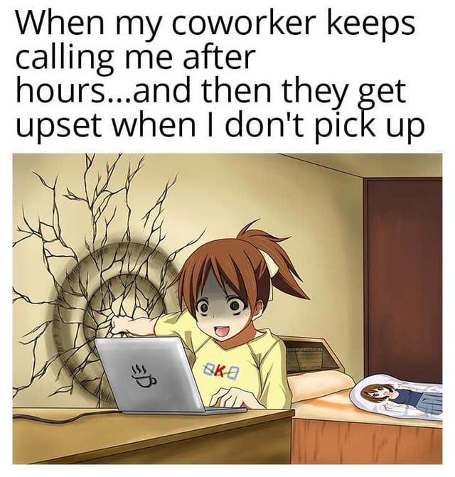 The meme consists of a top text overlay and an animated scene. The top text reads: 'When my coworker keeps calling me after hours...and then they get upset when I don't pick up'. Below the text is an anime-style illustration of a young girl with brown hair tied in a ponytail, wearing a yellow shirt with a blue 'KK' logo. She is seated at a wooden desk, typing on a silver laptop with a coffee cup sticker. Behind her, the beige wall has a large, spiderwebbed crack with a circular indentation, suggesting a previous impact. To her right, there is a wooden door, and a bed with a pillow featuring a small image of another character is visible in the foreground. The girl has a cheerful, almost mischievous expression, contrasting with the text's relatable frustration about after-hours work calls.