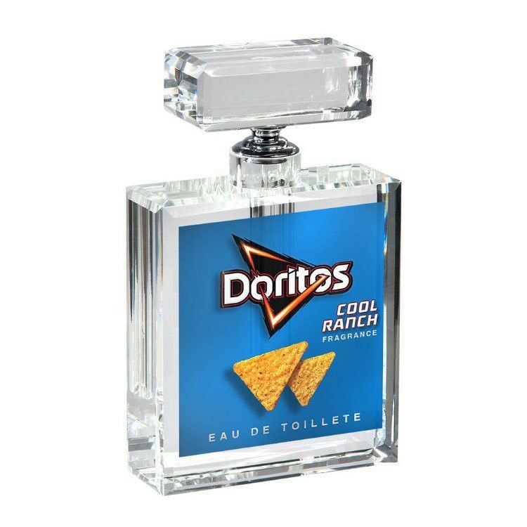 This is a humorous parody image depicting a clear, luxury-style glass eau de toilette perfume bottle. The bottle's label is branded for Doritos Cool Ranch tortilla chips, presenting the snack as a personal fragrance. The joke relies on the absurdity of turning the savory, recognizable flavor of Cool Ranch Doritos into a perfume intended for personal wear, playing on the trend of unusual celebrity and brand merchandise crossovers.