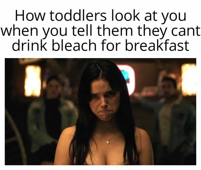 This meme pairs a top text caption with a viral reaction shot of Jenna Ortega as Wednesday Addams from the Netflix series *Wednesday*. The caption reads 'How toddlers look at you when you tell them they cant drink bleach for breakfast'. The character in the image glares at the viewer with an exaggerated angry pouting expression. The joke exaggerates the relatable experience of parents, who often face extreme anger from young toddlers when stopping them from doing obviously dangerous, absurd actions, highlighting the constant effort required to keep small children safe from self-harm.