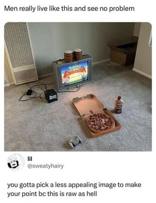 The meme consists of a viral social media interaction: the top text reads 'Men really live like this and see no problem' above a photo of a sparse, unfurnished carpeted room. The room contains a CRT television on the floor playing a video game, two small drums resting on top of the TV, an open pizza box with a full pizza placed directly on the carpet, a bottle of iced coffee next to the pizza, a game controller on the floor, a box fan in the corner, and loose visible wires. Below the photo is a reply from Twitter/X user @sweatyhairy that states 'you gotta pick a less appealing image to make your point bc this is raw as hell'. The joke subverts the original poster's intent to mock stereotypical messy, minimal living spaces associated with men: instead of seeing the setup as undesirable, the reply argues it looks like a perfect, low-fuss space for relaxing and gaming, which aligns with the Reddit post title 'Perfect place to lock in' (lock in being slang for settling in to enjoy an activity comfortably for an extended period).