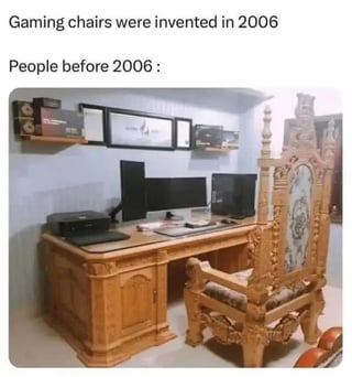 A meme contrasting the invention of gaming chairs in 2006 with the seating alternatives used before that time. The top text states 'Gaming chairs were invented in 2006' followed by 'People before 2006:' above an image of a modern wooden desk setup with two monitors paired with an ornate, old-fashioned wooden chair, creating a humorous anachronism by juxtaposing contemporary tech with vintage seating.