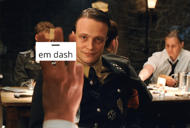 This meme uses a still from the 2009 Quentin Tarantino film *Inglourious Basterds* tavern interrogation scene, featuring the character Major Heinz Hellstrom smirking directly at an unseen person holding up their middle finger toward him. A text label is overlaid on the outstretched middle finger, displaying the long horizontal em dash punctuation mark above the text "em dash". The visual pun relies on the fact that the straight, horizontal raised middle finger, viewed head-on, looks identical to the em dash punctuation mark. Paired with its original title stating "With time it will be less and less obvious", the meme jokes that as familiarity with the em dash term declines over time, people will only recognize the image as an offensive gesture and miss the wordplay.