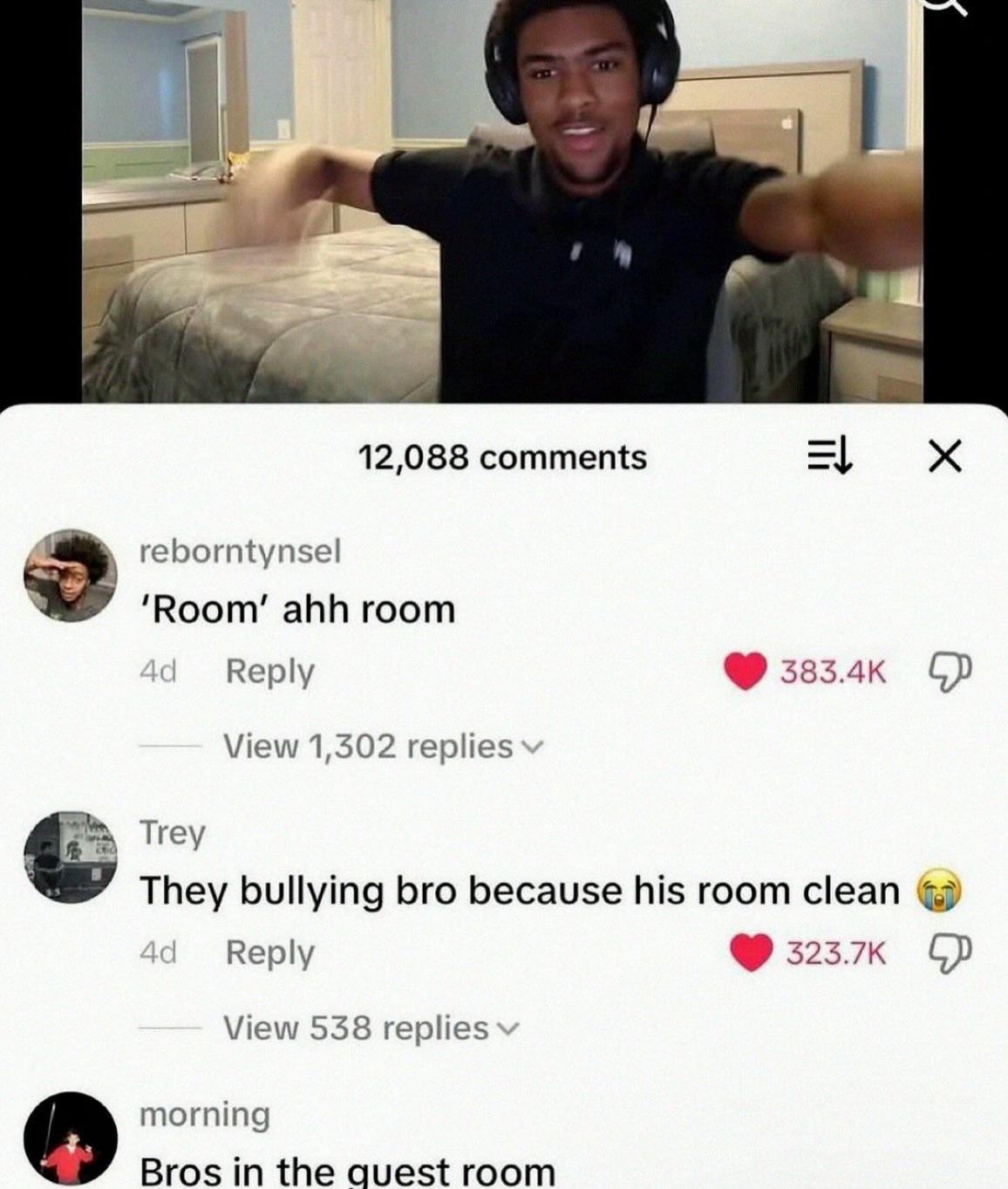 A screenshot of a social media post featuring a young man in a bedroom wearing headphones and gesturing with his arms outstretched. Below the image, there's a comment section showing 12,088 total comments. The top comments include 'Room ahh room' from user 'reborntynsel' with 383.4K likes, 'They bullying bro because his room clean' from user 'Trey' with 323.7K likes, and 'Bros in the guest room' from user 'morning'. The bedroom appears clean and well-organized with a bed, nightstand, and dresser visible in the background.