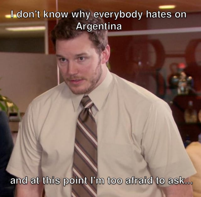 This is a reaction meme using a screenshot of the character Andy Dwyer, played by Chris Pratt, from the US sitcom Parks and Recreation. Text is overlaid on the top and bottom of the image: the top text states "I don't know why everybody hates on Argentina", and the bottom text reads "and at this point I'm too afraid to ask...". The character's confused, awkward, hesitant expression conveys the relatable feeling of being unaware of the reasoning behind a widely held popular opinion, but being too anxious to ask for clarification out of fear of seeming ignorant or causing offense.