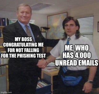 This is a single-panel static meme using a popular handshake scene from the US sitcom *The Office*. The smiling older man on the left is labeled "MY BOSS CONGRATULATING ME FOR NOT FALLING FOR THE PHISHING TEST", shaking hands with the younger, blank/confused looking man on the right, who is labeled "ME, WHO HAS 4,000 UNREAD EMAILS". The core ironic joke is that the employee is being praised for good cybersecurity awareness, when he actually passed the phishing test purely by accident because he never checks or opens his emails at all, so he never encountered the test phishing message.