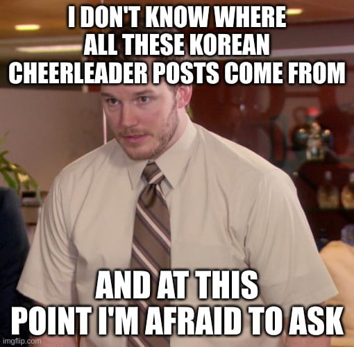 This is a single-panel reaction meme featuring a screenshot of actor Chris Pratt playing the character Andy Dwyer from the US sitcom *Parks and Recreation*. He is standing in an office setting with a confused, awkward, and perplexed expression. White bold text is overlaid at the top and bottom of the image: the top text reads "I DON'T KNOW WHERE ALL THESE KOREAN CHEERLEADER POSTS COME FROM", and the bottom text reads "AND AT THIS POINT I'M AFRAID TO ASK". The meme humorously expresses the relatable feeling of being out of the loop on a sudden, widespread social media trend, and being too embarrassed to ask for context about it.
