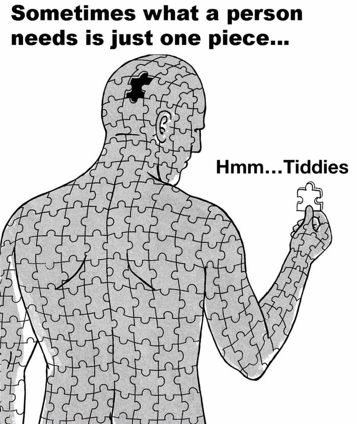 This is a black-and-white single-panel illustration showing a man whose entire body is constructed from interlocking jigsaw puzzle pieces, with exactly one puzzle piece missing from the section of his head corresponding to his brain. He holds a single loose puzzle piece up in his right hand, and his internal thought is written next to him as 'Hmm...Tiddies'. Text at the top of the image sets up the joke: 'Sometimes what a person needs is just one piece...'. The humor comes from subverting expectations: the opening line implies the missing piece is a meaningful, emotional, or mental element required to feel complete, but the punchline reveals the only missing piece the man desires is 'tiddies', a slang term for breasts, leaning into crude, relatable stereotypical male humor.