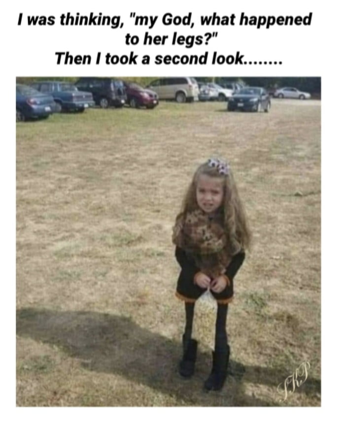 A photograph of a young girl standing in a grassy field with parked cars in the background. She is wearing a scarf, black top, black pants, and black boots, and is holding a bag of what appears to be popcorn in front of her legs. The text at the top creates a visual joke by suggesting the girl's legs initially appear unusual until you realize she's just holding a bag in front of them, creating an optical illusion.