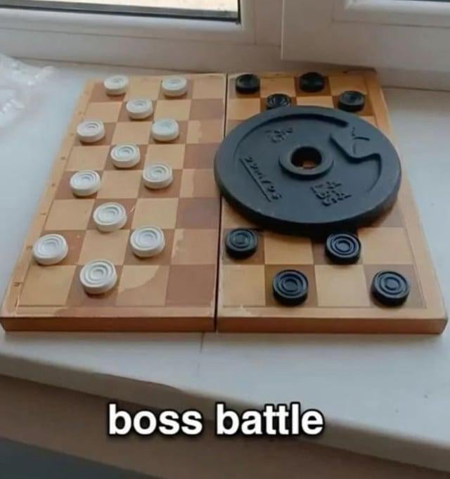 A photograph of a chessboard placed on a windowsill. The white side has standard white chess pieces arranged in their starting positions, while the black side has standard black pieces except for a large, circular weight plate (resembling a barbell weight) in place of the black king. At the bottom of the image, bold white text reads 'boss battle,' humorously comparing the oversized weight plate to a 'boss' enemy in gaming, which is typically larger and harder to defeat than regular opponents.