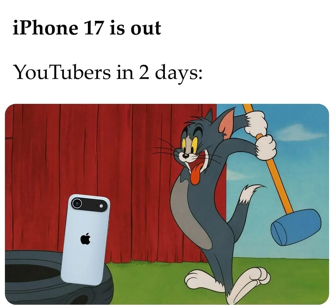 The meme consists of two text sections at the top: 'iPhone 17 is out' and 'YouTubers in 2 days:' followed by a scene from the animated series 'Tom and Jerry'. In the scene, Tom (the cat) is depicted with an excited, mischievous expression—tongue sticking out, eyes wide—while swinging a large blue mallet with both hands. To the left of Tom, there is a white iPhone (likely representing the iPhone 17) placed on top of a black tire, set against a red barn wall and green grass background. The humor lies in satirizing how quickly YouTubers create content (often involving dramatic or clickbait actions like 'smashing' new products) shortly after a major tech release.